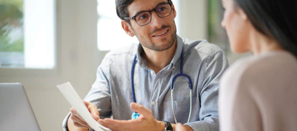 A doctor talks to a patient during a follow-up