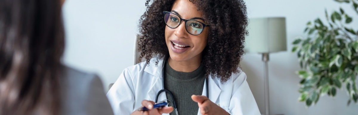 5 Facts About Glucose Monitoring Implants You Should Know-9 A doctor in a lab coat tells her patient about glucose monitoring implants and their benefits