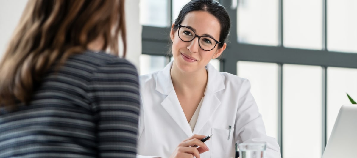 5 Reasons to Try Amino Acid Treatment-3-Doc A doctor in a lab coat listens to a patient as they discuss amino acid treatment