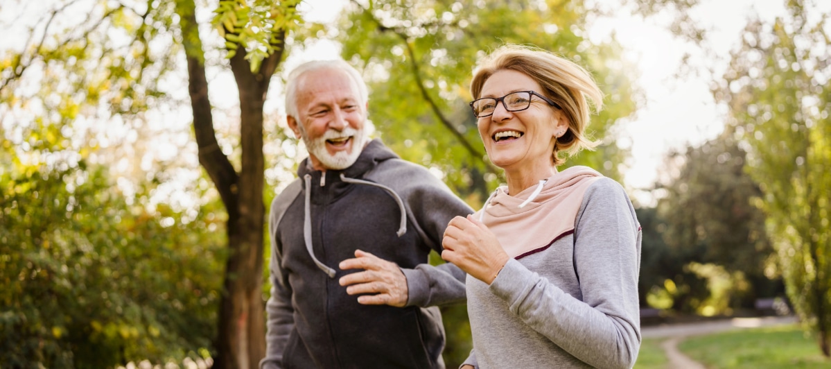 5 Reasons to Try Amino Acid Treatment-6-Joggers An older couple smile as they jog in the park after amino acid treatment