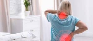 A patient holding their neck and back in pain