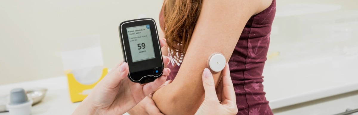 A Beginner’s Guide to CGM Glucose Monitors-2 A doctor checks a patient's CGM glucose monitor
