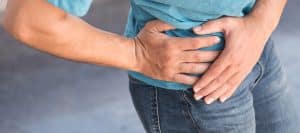 A woman holds her hip due to chronic pelvic pain