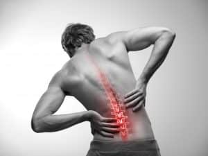 Man hold his lower lumbar back with glowing red to symbolize inflammation