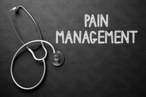 Medical Concept: Pain Management Handwritten on Black Chalkboard. Top View of White Stethoscope on Chalkboard. Medical Concept: Pain Management Handwritten on Black Chalkboard. 3D Rendering.