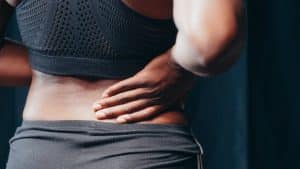 Woman with chronic back pain holding her lower back