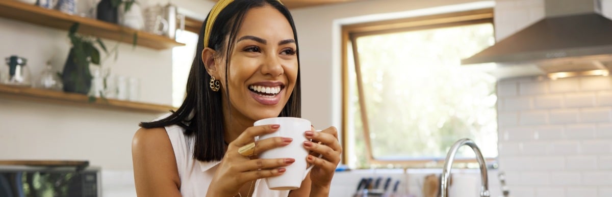 Can Electrical Stimulation Help Neuropathy in Feet-5-Coffee A woman smiles as she holds a mug of coffee after peripheral nerve stimulation