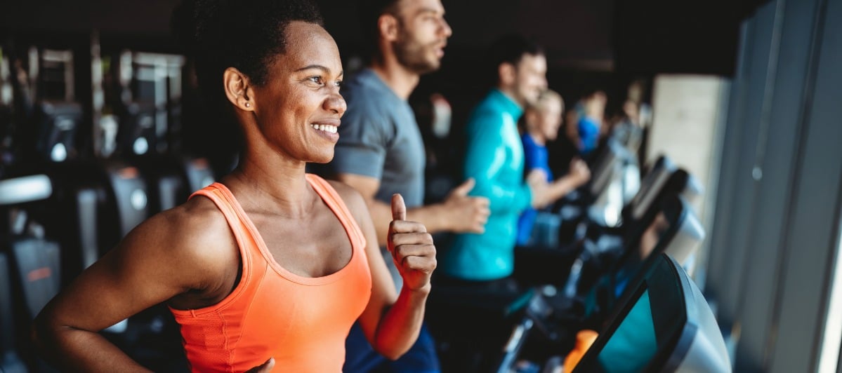 Can Epidural Injections Help Your Lower Back Pain-6-Gym A woman smiles as she runs on the treadmill at a gym after a lumbar epidural injection for lower back pain