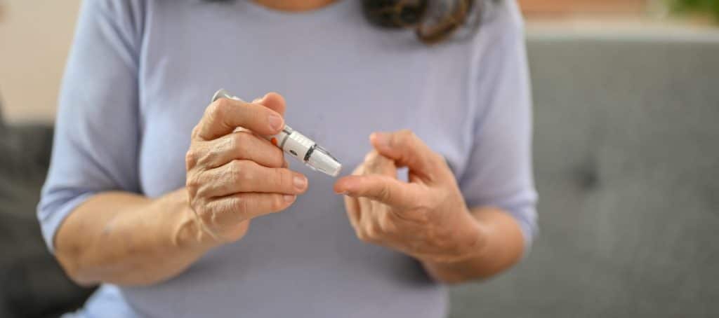 A woman pricks her finger to check her blood sugar levels due to diabetic neuropathy