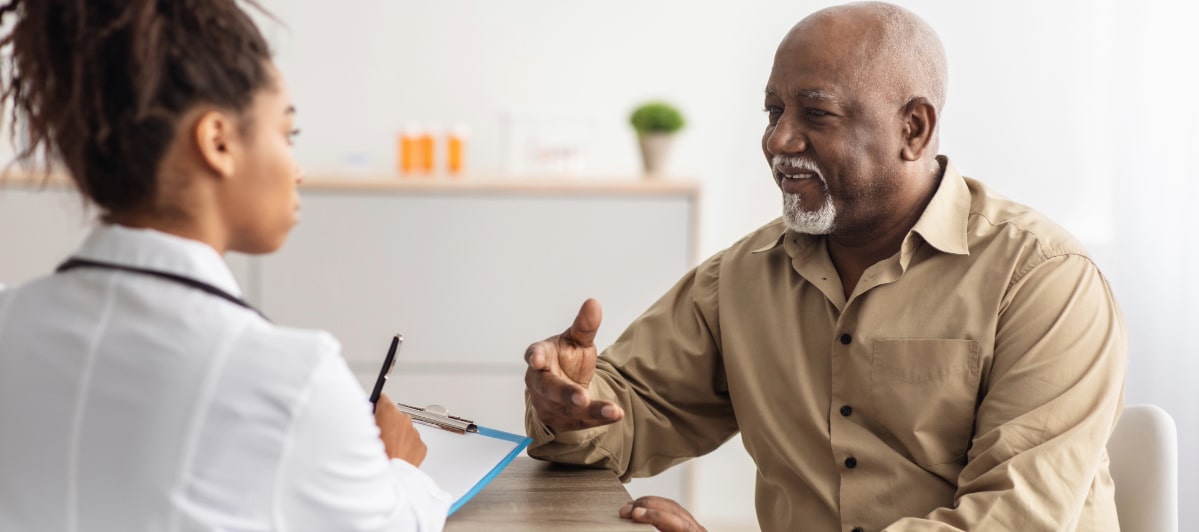Explore 5 Symptoms of Middle Back Pain-3-Patient A patient describes his symptoms of middle back pain to a doctor