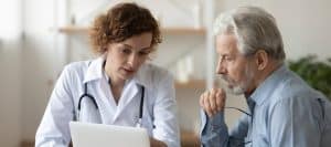 A doctor in a lab coat talks to a patient about types of types of nerve stimulators