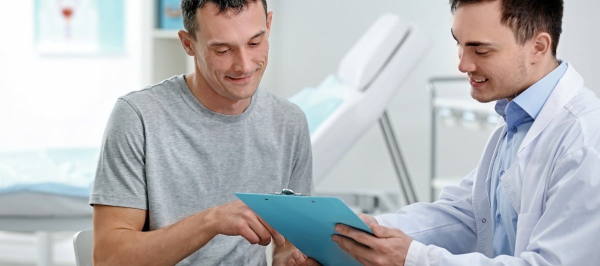 Exploring Neurostimulation Devices and Treatments-5-Guy A patient points to a paper about types of nerve stimulators while talking to a doctor