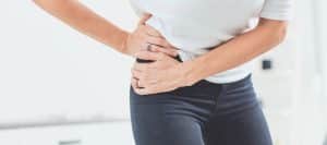 A woman holds her hip in pain before a hip fusion procedure