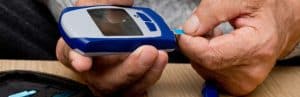 A person with diabetes gets ready to check glucose levels with a glucometer kit
