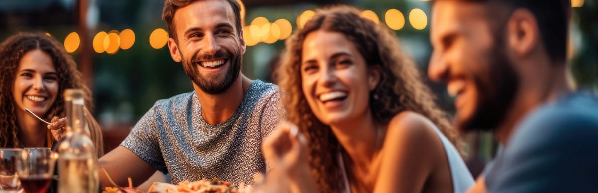 Glucometer Kits Explained-5 A group of people smile as they enjoy dinner with stable glucose levels