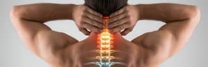 A man puts his hands to his back as he experiences upper middle back pain