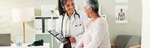 A doctor smiles as she tells her patient about Emsculpt Neo treatment
