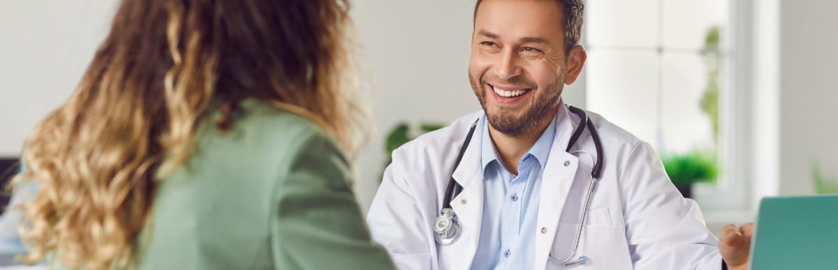 Heart Disease Symptoms You Need to Know - 2026-07-15T110257.745 A doctor in a lab coat smiles as he tells a patient about Emsculpt Neo treatment
