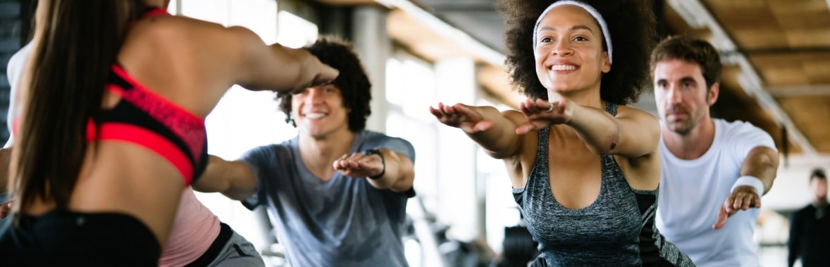 Heart Disease Symptoms You Need to Know (40) A woman smiles as she holds a pose during an exercise class after epidural pain management