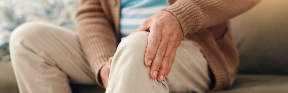 Heart Disease Symptoms You Need to Know (42) A man holds his knee in pain which is one of the early signs of autoimmune arthritis