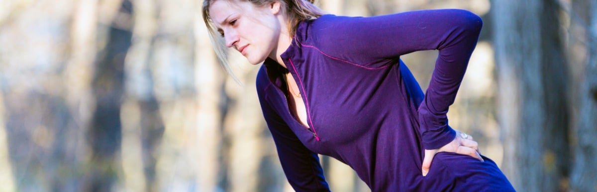 Heart Disease Symptoms You Need to Know (57) A jogger stops during a run to hold her lower back in pain