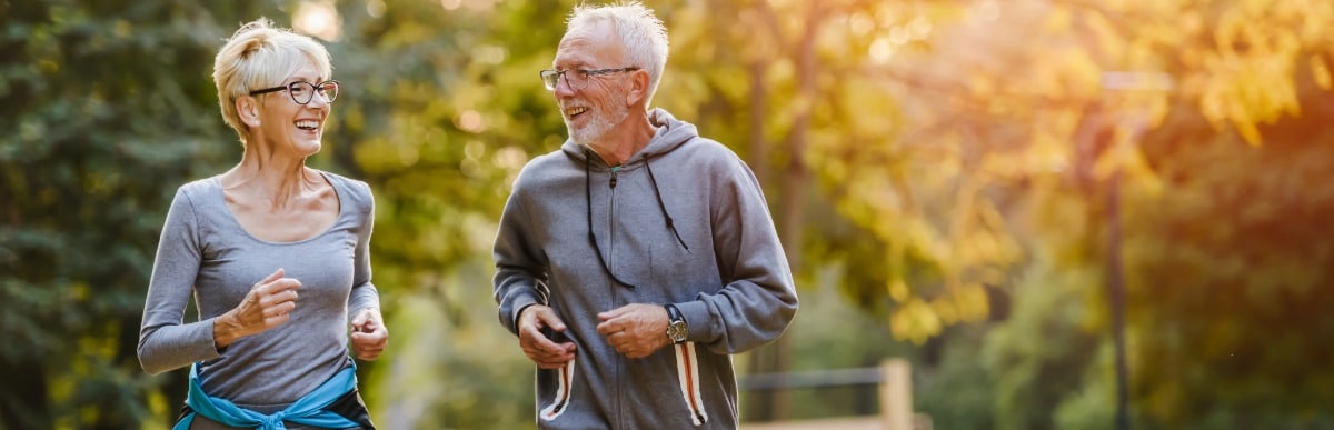 Heart Disease Symptoms You Need to Know (69) An older couple smile as they jog on a nature trail
