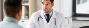 A doctor in a lab coat talks to a patient about about kyphoplasty recovery time