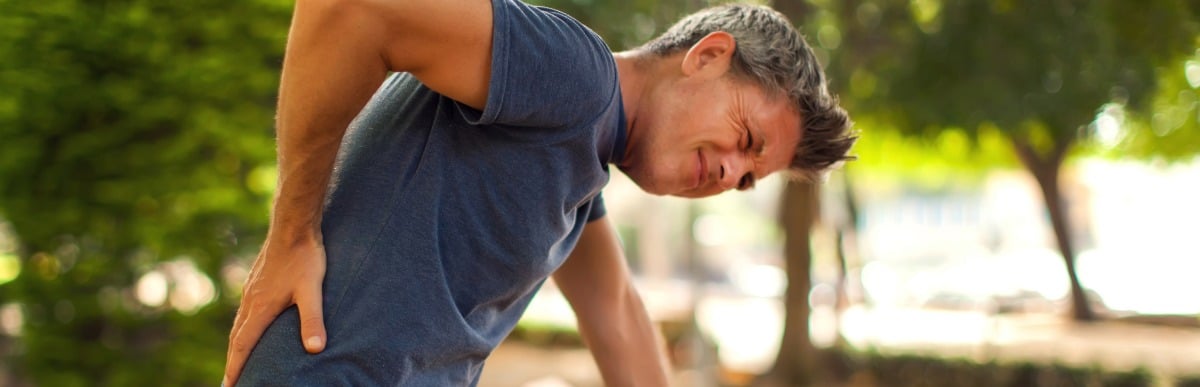Heart Disease Symptoms You Need to Know (79) A man bends over and holds his back in pain before he has kyphoplasty to ease pain