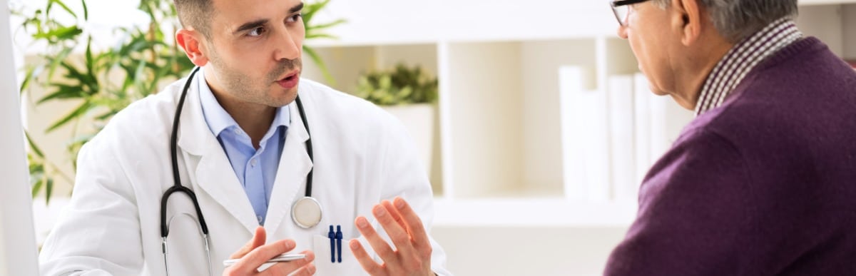 Heart Disease Symptoms You Need to Know (83) A doctor in a lab coat talks about myofascial pain syndrome with a patient
