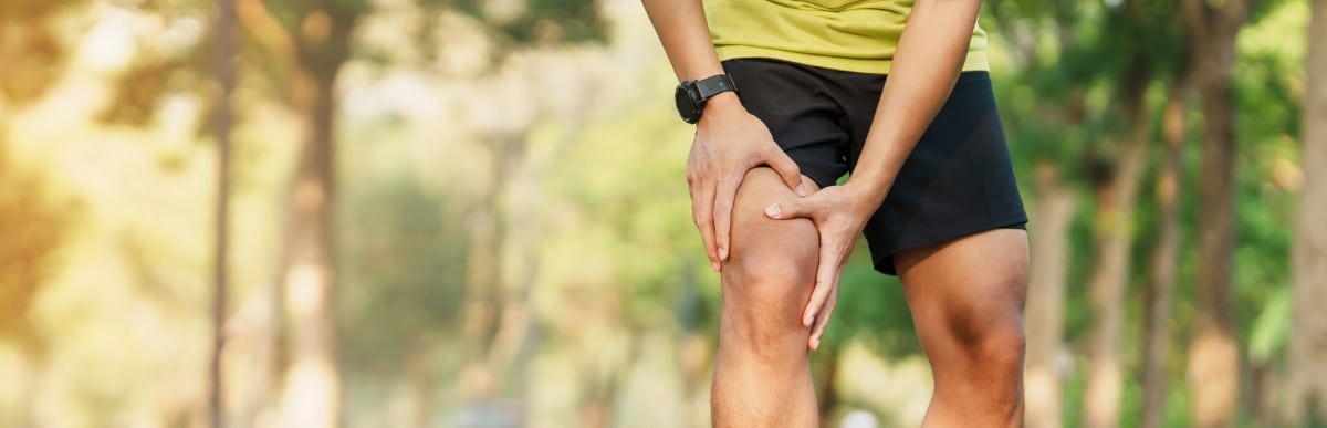 Heart Disease Symptoms You Need to Know (88) A runner stops and grabs his knee due to chronic pain before exploring non-surgical treatment options