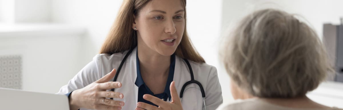 Heart Disease Symptoms You Need to Know (91) A doctor in a lab coat tells her patient about non-surgical treatments for chronic pain