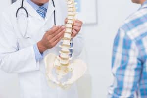 Comprehensive Pain Management doctor pointing to a spine