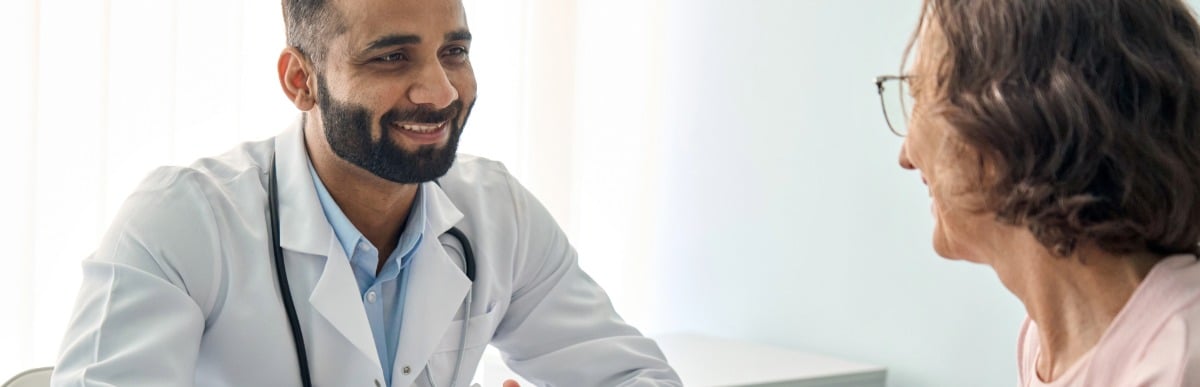 How Diabetes Management Programs Revolutionize Care-2 A doctor in a lab coat smiles as he tells a patient about diabetes mangement programs