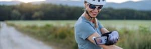 A biker smiles as she takes a break from a ride to check her glucose as part of her diabetes management programs