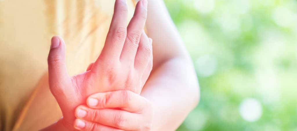 A person rubs their numb hands due to diabetic neuropathy