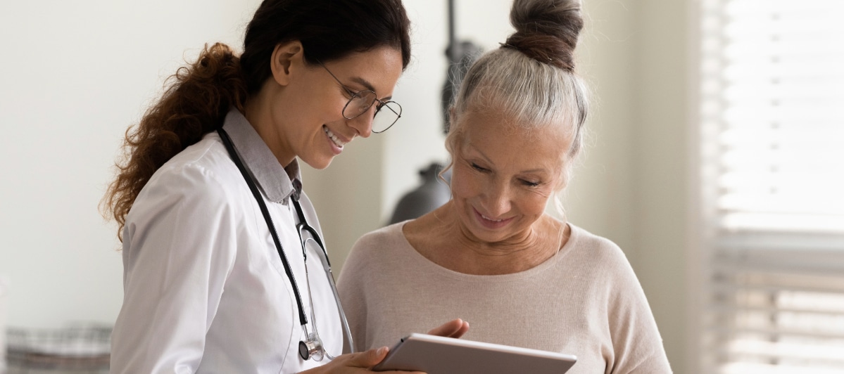 Ideal Candidates for Kyphoplasty-5-Doc A doctor in a lab coat smiles as she talks to a patient about kyphoplasty treatment