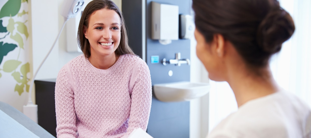 Ideal Candidates for Kyphoplasty-7-Patient A woman smiles as she talks to her doctor about kyphoplasty treatment