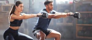 Two people exercising with free weights