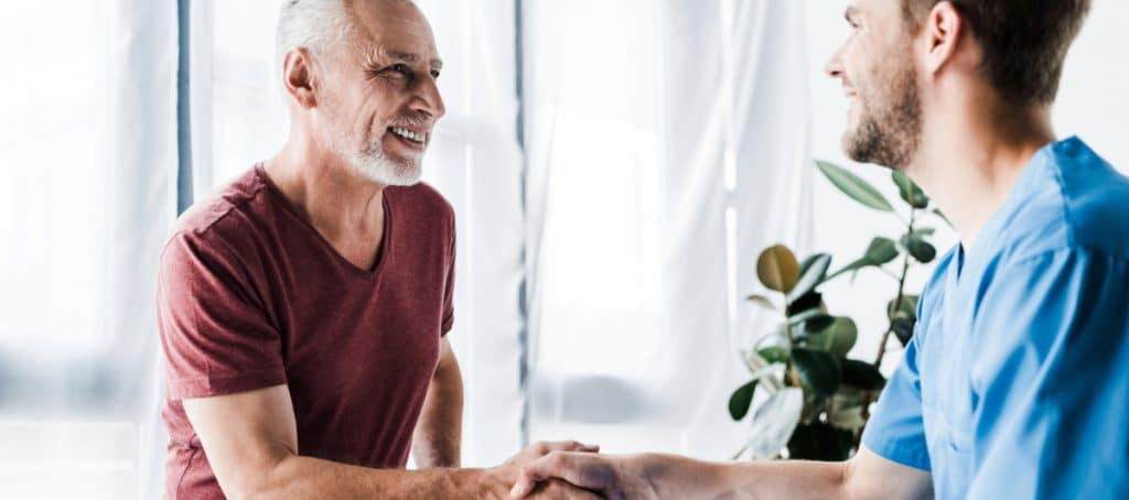 A patient smiles and shakes his doctr's hand