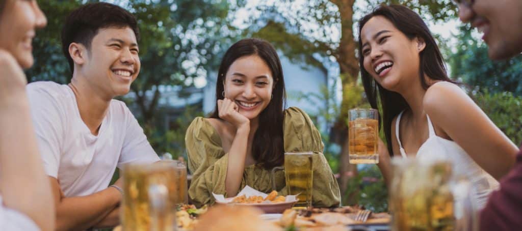 A group of people smile around a dinner table