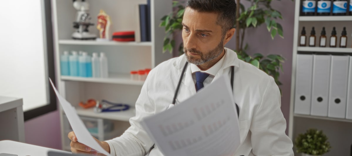 Is Hormone Replacement Therapy Right for Me-3-Doc A doctor in a lab coat examines medical records to determine if hormone replacement therapy is right for a patient