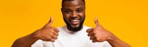 A man smiles and gives thumbs up after trigger finger treatment