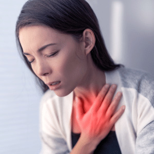 A women suffering from shortness of breath holding her chest