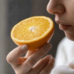 A women suffering from loss of smell trying to smell an orange