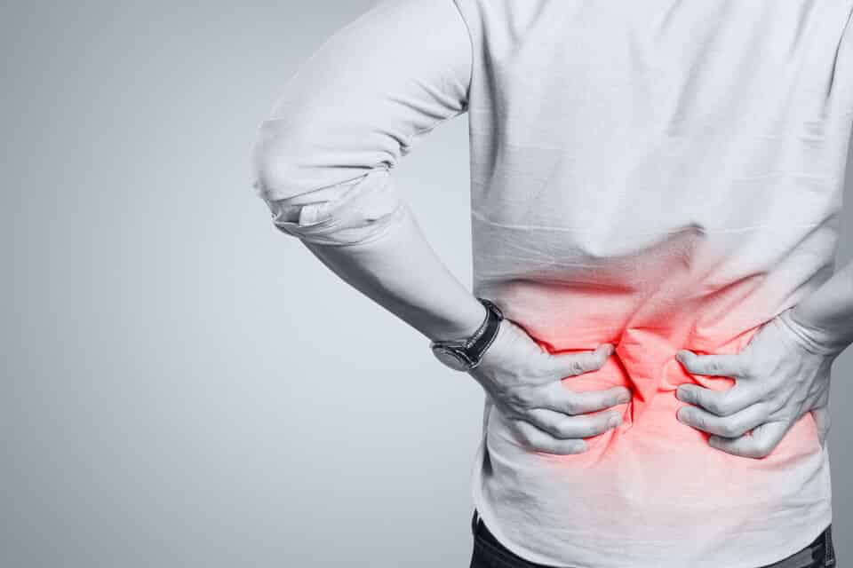 Lower Back Pain-1 A man with lower back pain holding his lower back