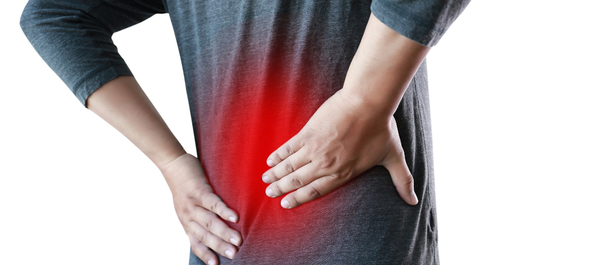 A man in a black shirt holding his back due to chronic back pain.