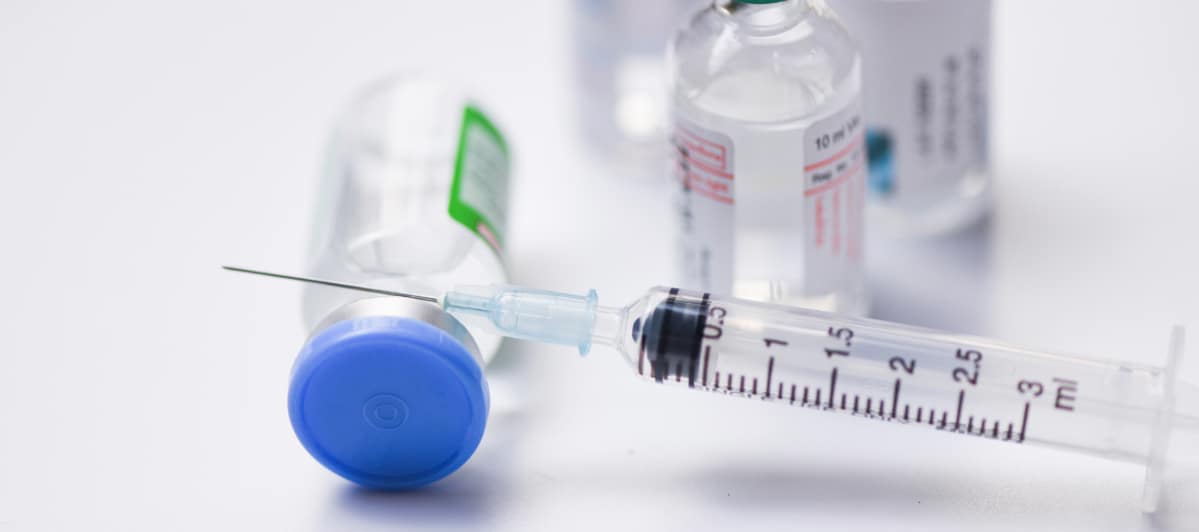 Overcoming Spinal Stenosis Treatment Options and Success Rates-3-Injection An injection needle rests on a vial for spinal stenosis treatment