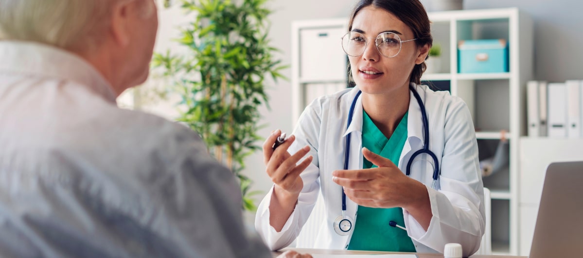 Overcoming Spinal Stenosis Treatment Options and Success Rates-4-Doc A doctor in a lab coat discusses spinal stenosis treatment options with a patient