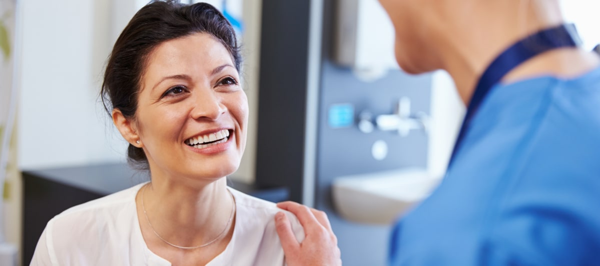Overcoming Spinal Stenosis Treatment Options and Success Rates-8-Patient A patient smiles as her doctor discuss spinal stenosis treatment options