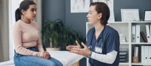 A doctor in scrubs tells her patient about treatment with a peripheral nerve stimulator